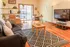 Inviting open-plan living area featuring warm hardwood floors, cozy sofa, and modern decor, with natural light pouring through large windows.