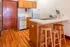 Charming kitchen with sleek countertops, a cozy breakfast bar, and natural wood cabinets, creating a warm and inviting space.