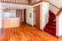 Charming apartment interior with elegant wooden floors, cozy red-carpeted staircase, and a sleek kitchen island for modern living.