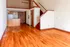 Charming open-concept apartment featuring elegant hardwood floors, a cozy loft area, and a compact kitchen with wood cabinetry.