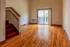 Bright living area with gleaming hardwood floors, large windows for natural light, and access to a private balcony.