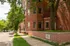 Charming red brick apartment building at 402 W. Dayton, surrounded by lush greenery and a serene urban street.