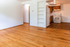 Inviting open-plan living area with warm hardwood floors, modern kitchen, and built-in shelving.