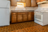 Charming kitchen with warm wooden cabinets, modern appliances, and a classic tiled floor.