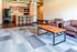 Modern open-plan living space with cozy seating, elegant kitchen, and stylish bar stools on a chic patterned carpet.