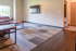 Bright, inviting living room with modern decor, featuring comfortable seating, a mounted flat-screen TV, and large window for natural light.