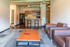 Modern apartment interior featuring an open-concept living room with plush sofas, a sleek kitchen with bar seating, and elegant finishes.