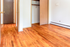 Bright room with polished hardwood floors and two open closets, offering ample storage space and natural charm.