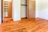 Spacious room with warm hardwood floors and ample closet space, ideal for creating a cozy living area or stylish bedroom.