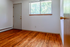 Inviting room with warm hardwood floors and a bright window view, perfect for personalization and comfort.