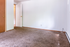 Bright and inviting empty room featuring plush carpeting, wooden doors, and a neutral color palette, ready for personalized styling.