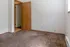 Cozy room with soft carpet flooring, wooden door, and ample natural light, perfect for a peaceful retreat.