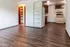 Inviting open-concept living space with elegant wood flooring, built-in shelving, and a cozy kitchen perfect for modern living.