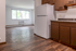 Inviting apartment interior featuring a bright, open living space with large windows, natural wood floors, and a modern kitchen ready for culinary inspiration.