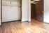 Bright room featuring elegant wood flooring and a spacious closet, exuding warmth and style.