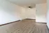 Inviting apartment featuring elegant wood flooring, bright white walls, and a modern ceiling fan, perfect for spacious living.