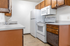 Charming kitchen with classic wooden cabinets, modern appliances, and sleek countertops, offering a cozy cooking space.
