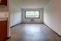 Bright and airy living space with large window and chic hardwood floors, perfect for modern living.