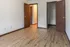 Bright, modern bedroom with elegant wood flooring and an open closet, perfect for stylish living.