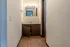Elegant apartment bathroom featuring warm wooden flooring, a wide vanity mirror, and bright lighting for a welcoming ambiance.