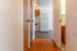 Inviting hallway space leading to a bright kitchen with modern appliances and warm wooden flooring.