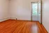 Bright and inviting room with polished hardwood floors, large window, and door leading to scenic views.