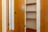 Beautifully crafted wooden closet with multiple shelves offering ample storage space, set against a warm-toned hardwood floor.