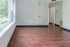 Charming open-concept room with sleek wooden floors, abundant natural light from a large window, and a convenient built-in closet.
