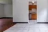 Bright and inviting apartment interior featuring sleek, tiled flooring leading to a cozy kitchen with wooden cabinetry and stainless steel appliances.