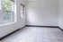 Bright and inviting room with large windows and tile flooring, perfect for a cozy sunlit space.