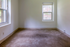 Bright empty room with large windows offering serene views, perfect for customization and personal touches.