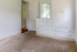 Bright and serene bedroom featuring plush carpeting, built-in white cabinetry with ample storage, and an inviting mirror that enhances natural light.