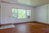 Bright room with large windows letting in natural light, featuring wood flooring and built-in storage, perfect for customization.