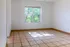 Bright and airy room with large window, offering lush green views and tiled flooring, perfect for a cozy retreat.