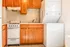 Charming kitchen nook with warm wooden cabinetry, modern oven, and convenient in-unit laundry.