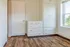 Bright and inviting room with elegant built-in white cabinetry, showcasing charming wooden floors and a large window pouring in natural light.