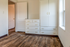 Charming bedroom with elegant white built-in cabinets, hardwood floors, and inviting natural light.