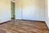 Bright and airy room with elegant wood flooring, built-in storage, and an inviting open door.