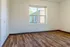 Bright and inviting room with elegant wood flooring and a large window offering a picturesque view.