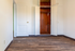 Charming room with elegant wood flooring and a spacious wooden closet, perfect for stylish living.