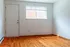 Bright and inviting room with polished hardwood floor, large window, and sunny ambiance.