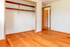 Bright and inviting empty room with polished hardwood floors, spacious closet, and natural light streaming through the doorway.