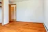 Cozy corner view featuring warm hardwood flooring and soft white walls, offering a perfect blank canvas for personalization.