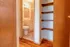 Inviting bathroom with charming tiles and warm wood shelving, perfect for cozy living.