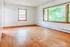 Bright and spacious room with elegant wood flooring and large windows, offering abundant natural light and serene outdoor views.