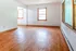Bright and inviting living space featuring elegant hardwood flooring and abundant natural light from large windows.