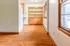 Bright and inviting space with warm hardwood floors and large windows, featuring a charming built-in cabinet for stylish storage solutions.