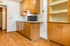 Inviting kitchen with warm wooden cabinets, ample storage space, and sleek countertops, perfect for culinary enthusiasts.