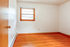 Bright, spacious room with gleaming hardwood floors and a large window, perfect for a cozy bedroom or inspiring home office.