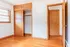 Bright and inviting bedroom with natural wood flooring, built-in closet, and ample sunlight from large windows.